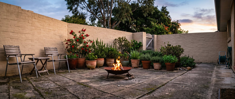 A compact fire bowl burning in a small paved Australian courtyard