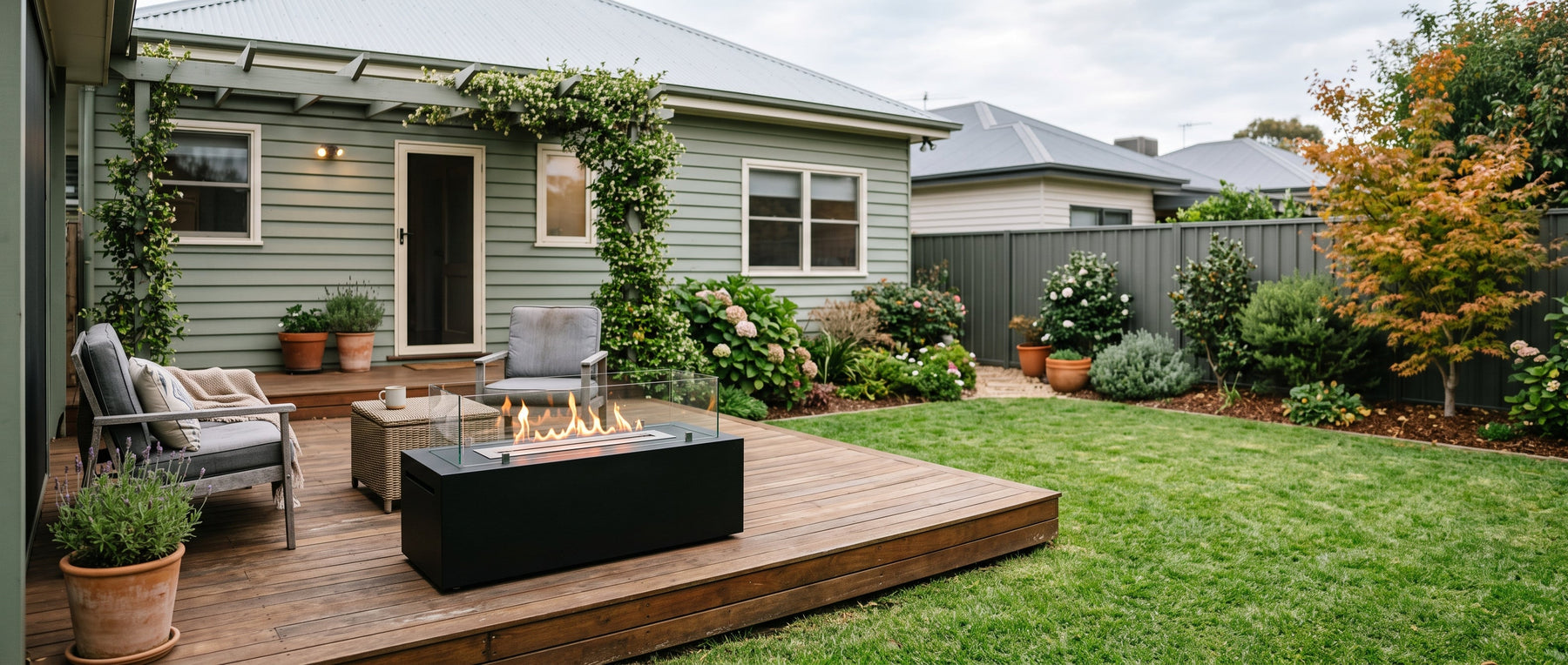 Rectangular bioethanol fire table with a linear flame on a timber deck