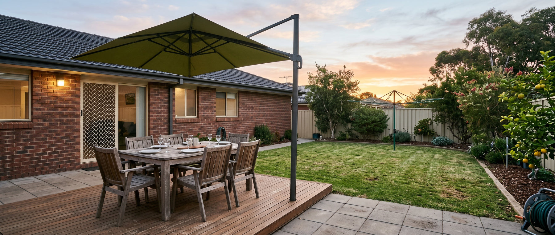 Large square cantilever patio umbrella shading an outdoor dining table for six in a tidy Australian suburban backyard