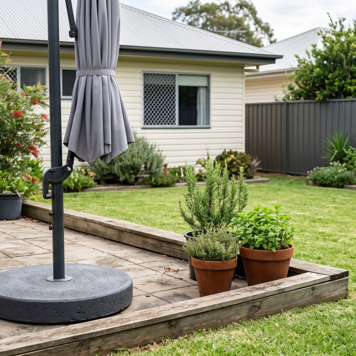 Heavy round concrete umbrella base at the foot of a cantilever umbrella stand