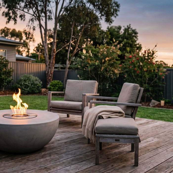 A bioethanol fire pit with a contained flame on a timber deck in a tidy Australian suburban backyard at dusk
