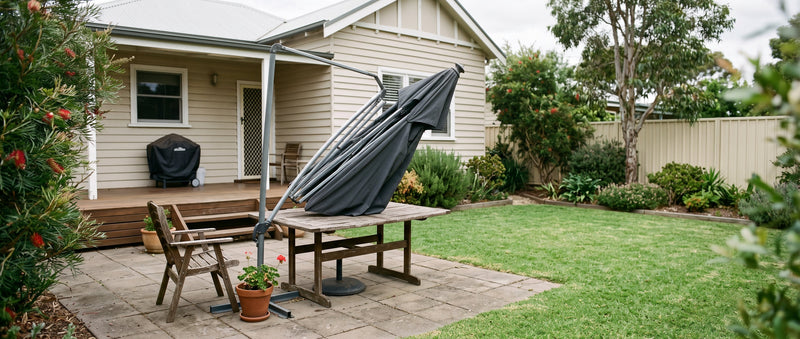 Closed cantilever patio umbrella with a visibly bent rib on the frame