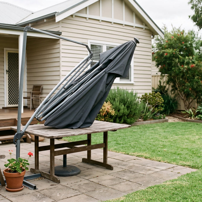 Closed cantilever patio umbrella with a visibly bent rib on the frame