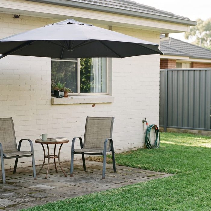Wall-mounted umbrella on a bracket shading two chairs on a small suburban patio