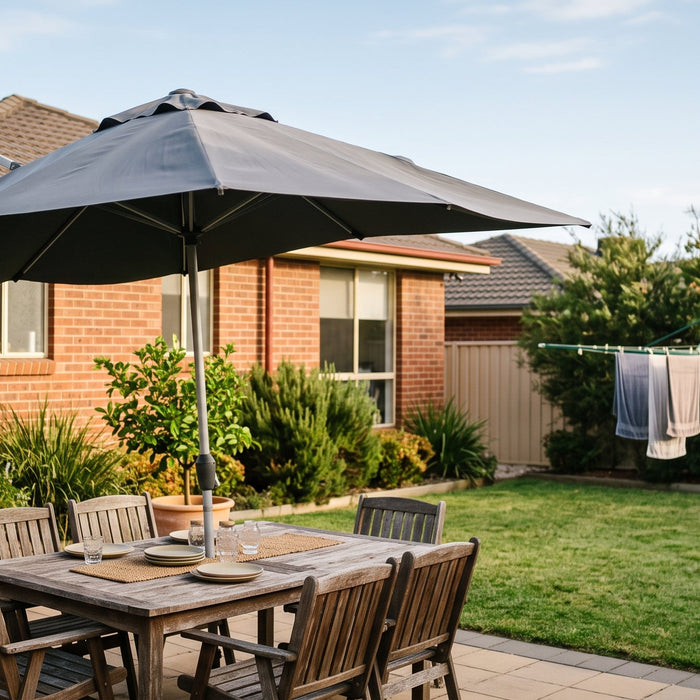 Cantilever patio umbrella catching a breeze over a timber deck dining setting in a tidy Australian suburban backyard