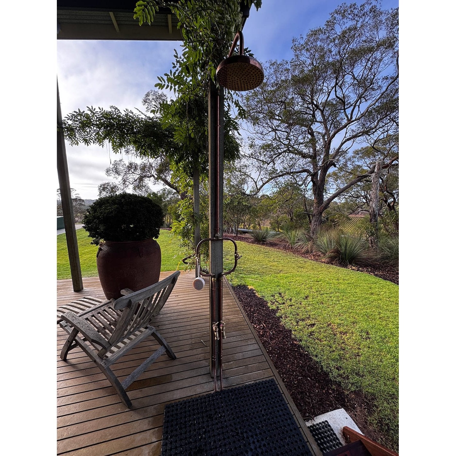 Handmade Waratah slim copper and brass hot and cold outdoor shower on a post.