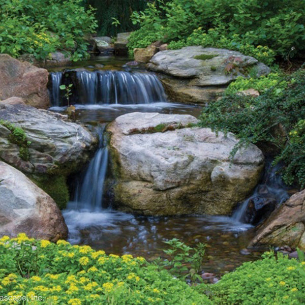 A 5m pondless waterfall built with the Aquascape Medium Pondless Waterfall Kit, cascading over stone into a rock-filled reservoir