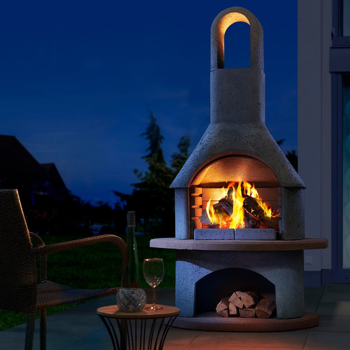 Buschbeck Carmen with a log fire burning at dusk beside outdoor seating