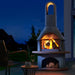 Buschbeck Carmen with a log fire burning at dusk beside outdoor seating