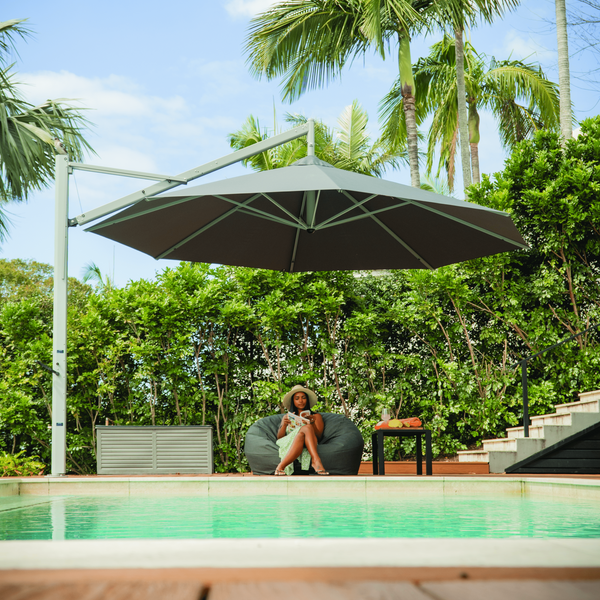 Revolvashade Signature Range cantilever umbrella with a charcoal canopy shading a poolside deck