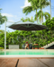 Revolvashade Signature Range cantilever umbrella with a charcoal canopy shading a poolside deck