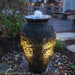 Stacked Slate Urn fountain at night, lit with spotlights sold separately