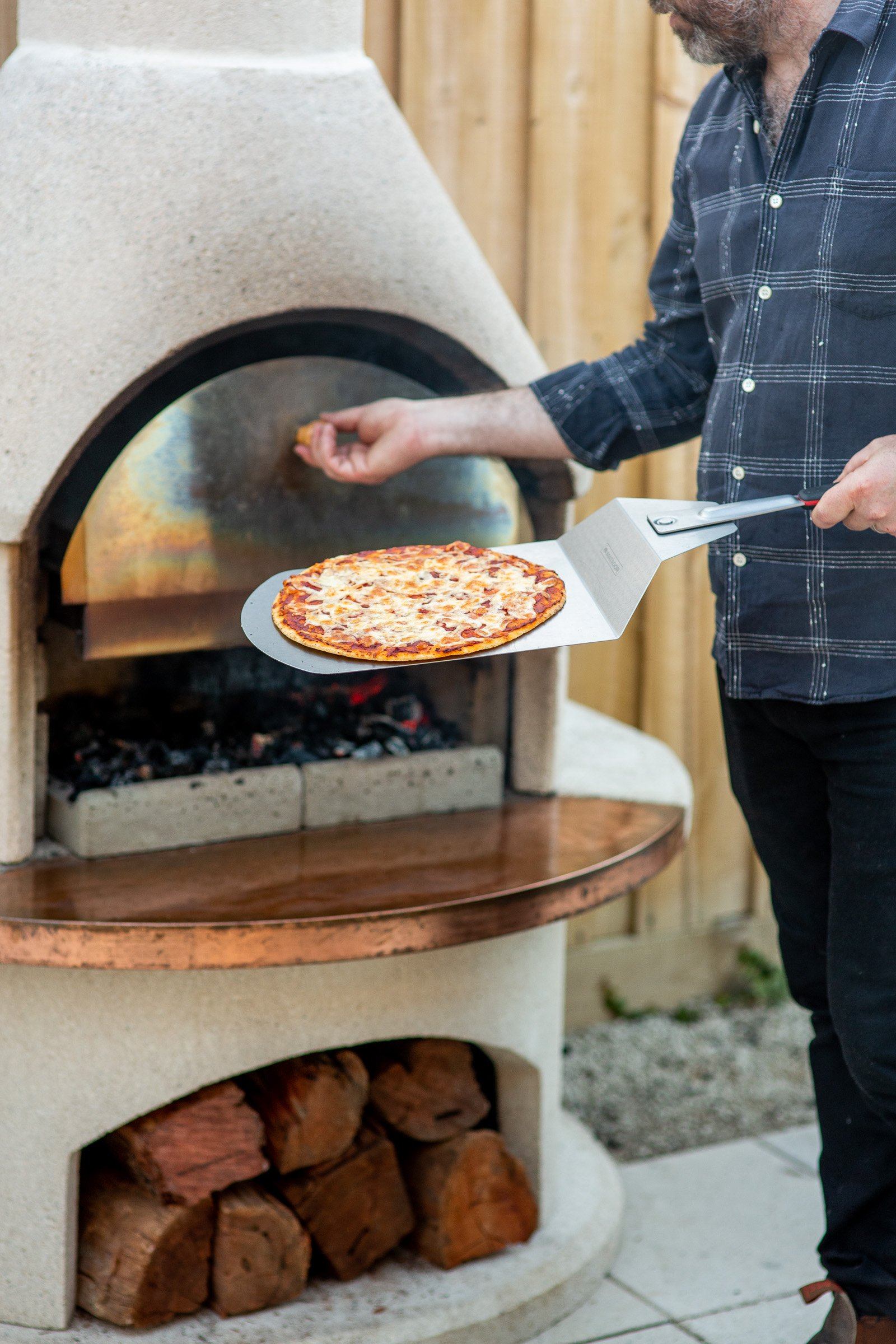 Sliding a pizza into the Buschbeck pizza insert fitted in a Rondo