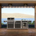 Coleman Revolution 4 Burner outdoor kitchen in Black Gloss on a timber deck under a pergola overlooking water