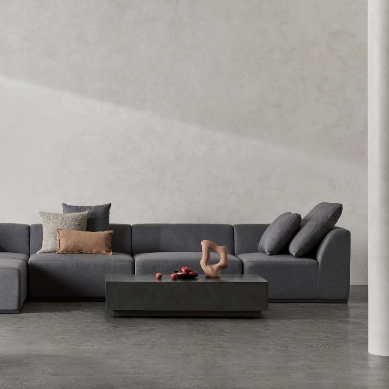 Dash 50 rectangular concrete coffee table in graphite finish styled in a minimalist modern lounge interior.