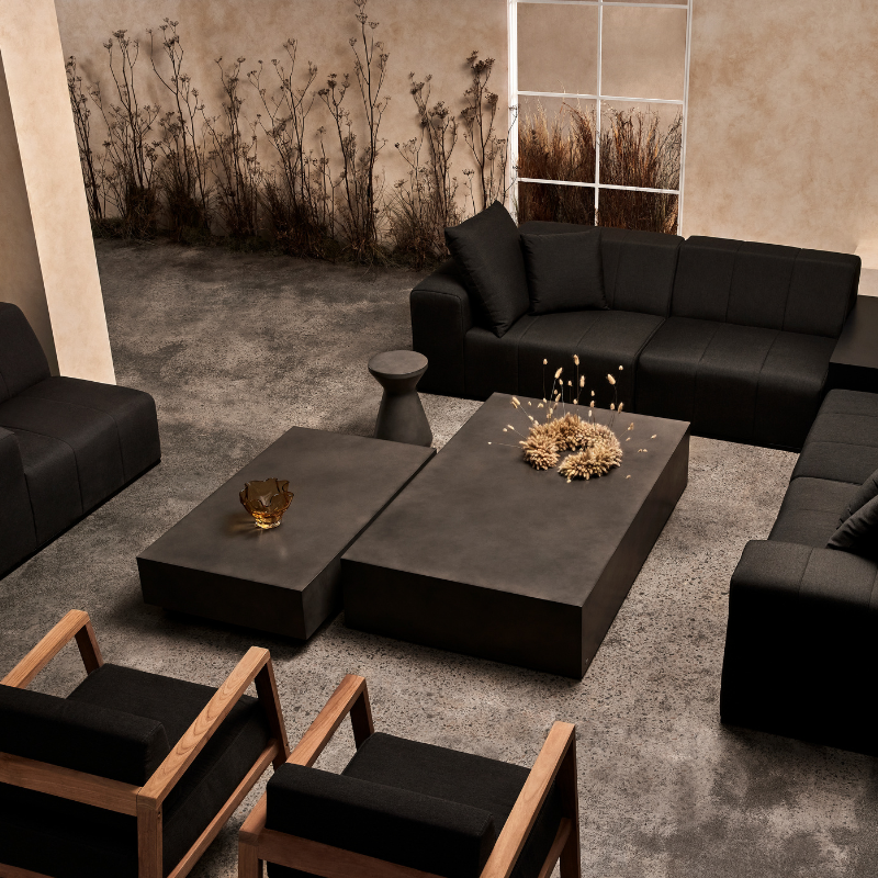 Move 65 concrete coffee tables arranged in a lounge setting with modular seating and decorative accents