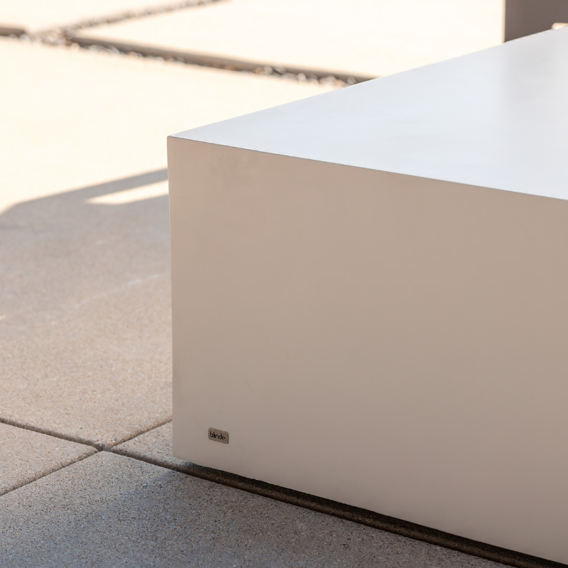 Close-up detail of Move 65 rectangular coffee table in bone white concrete finish on outdoor patio
