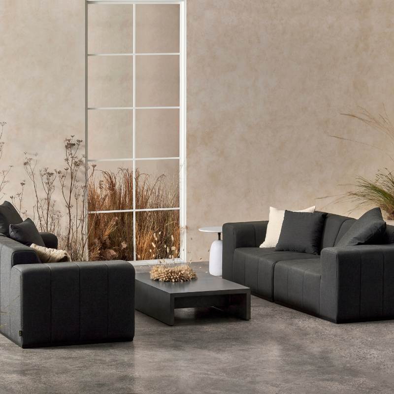 Niche 50 concrete coffee table in graphite finish styled in a contemporary lounge setting