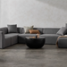 Node 30 round concrete coffee table in graphite finish styled in a modern living room with sectional sofa