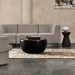Node 30 round concrete coffee table in graphite finish styled in a contemporary lounge setting