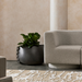 Stitch 25 concrete planter styled indoors beside a modern lounge chair with leafy plant