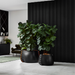 Large Blinde Stitch concrete planters with indoor plants displayed in a contemporary interior with a black feature wall