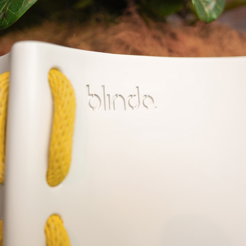 Close-up detail of the Blinde logo on a white Stitch 125 concrete planter with yellow stitched accent