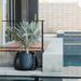 Blinde Stitch 75 concrete planter with yellow stitched detail placed poolside on a modern outdoor patio with a palm plant