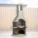 Buschbeck St Moritz 3-in-1 outdoor fireplace, BBQ and pizza oven with copper shelf and wood store, shown in a backyard setting
