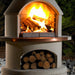 Buschbeck St Moritz Outdoor Fireplace with the fire lit at night in a garden setting