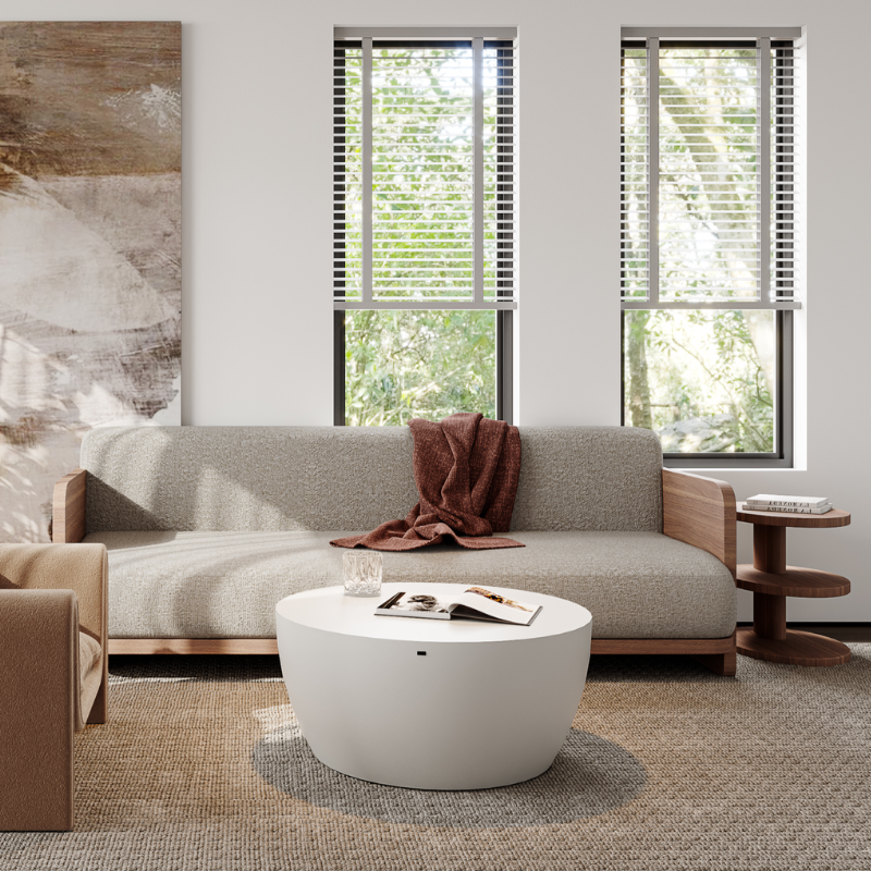 White Circ 40 round coffee table styled in a modern living room with sofa, rug, and natural light