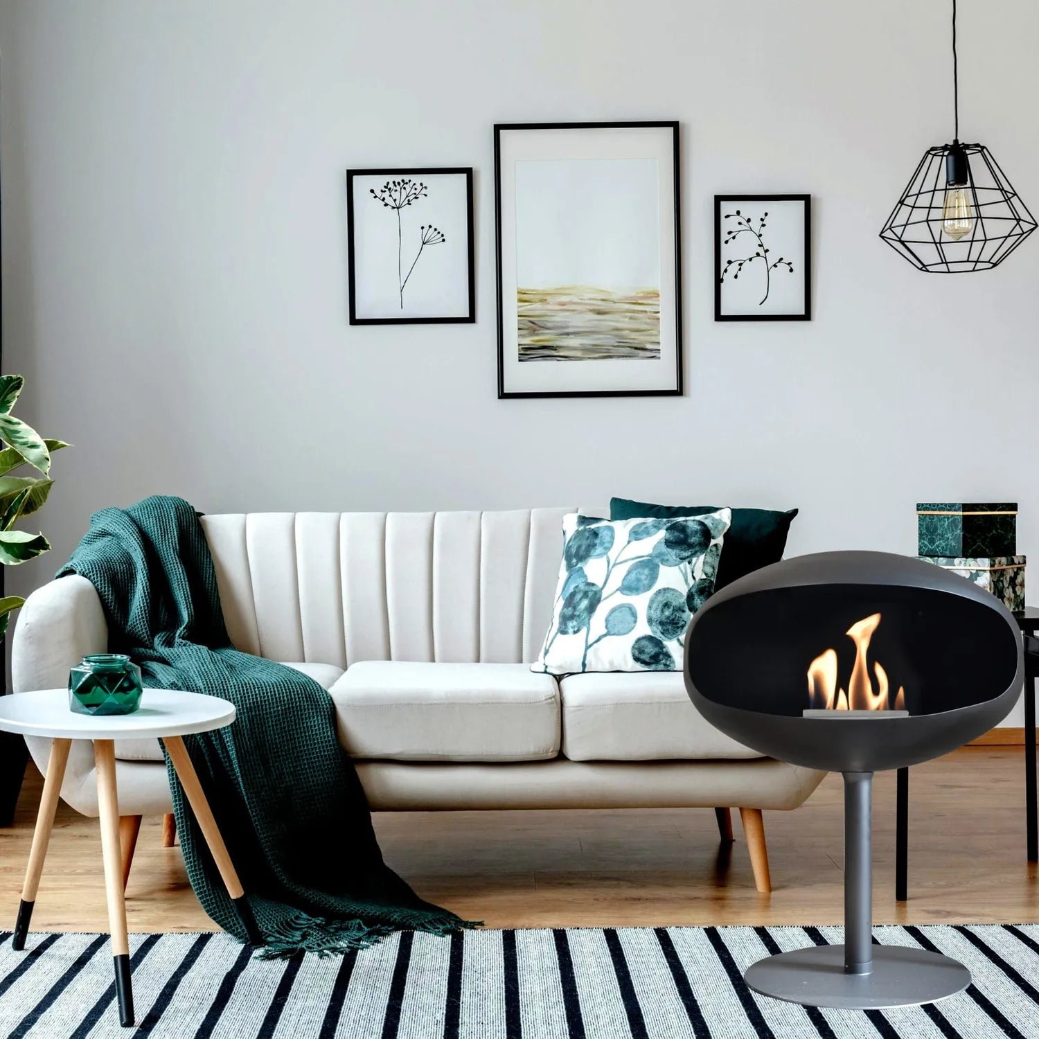 Cocoon Pedestal Bioethanol Fireplace in matt black in a living room beside a cream sofa