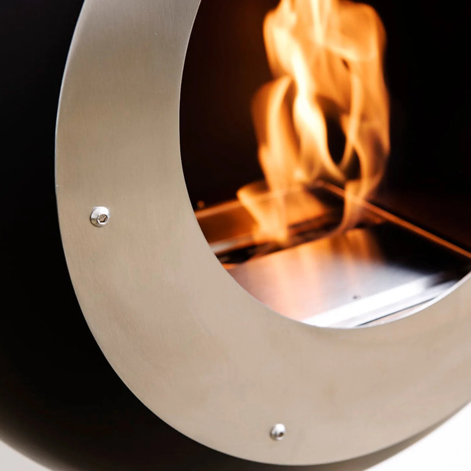Cocoon Vellum Wall Mounted Bioethanol Fireplace in black, close view of the flame and stainless fascia ring