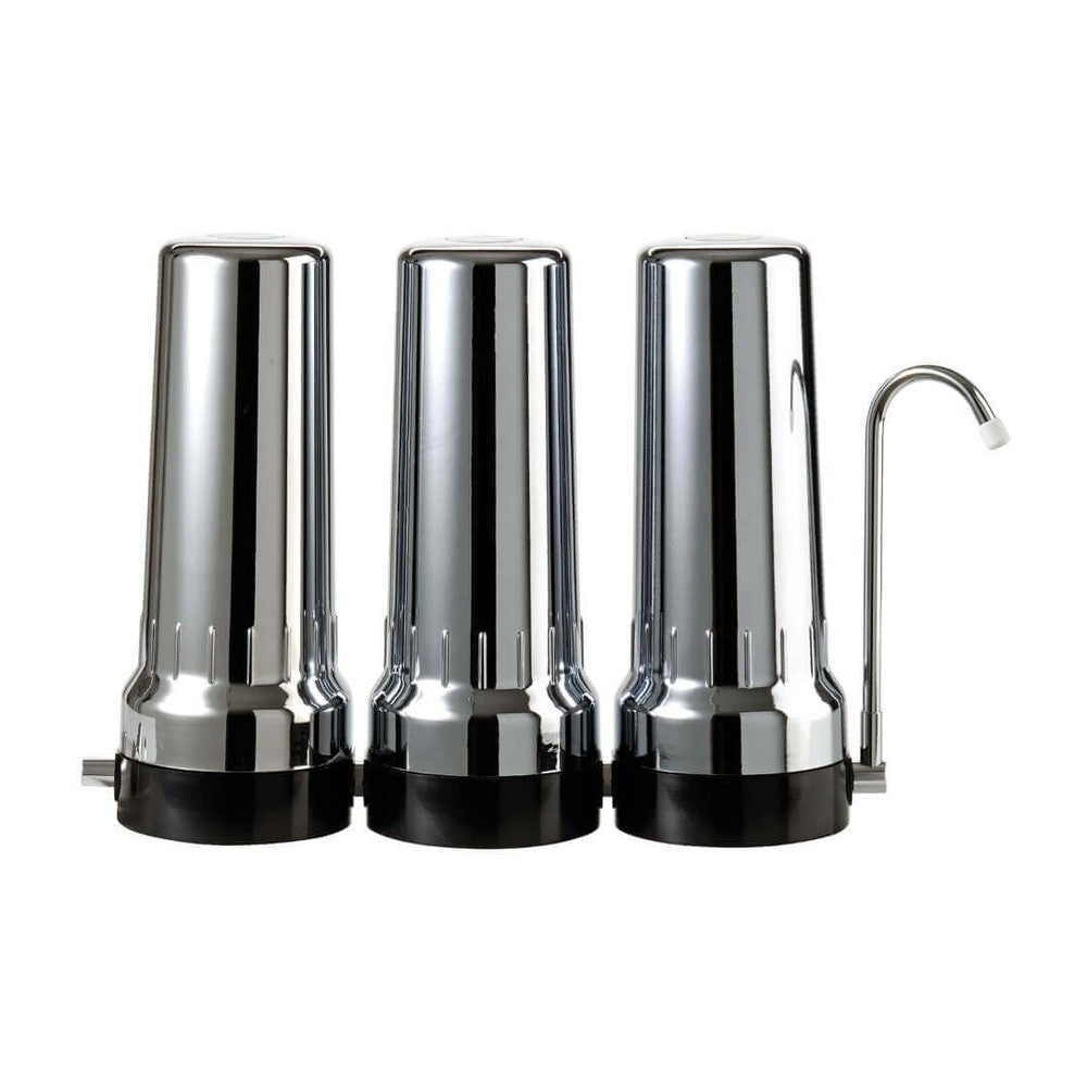 Depural Trio benchtop water filter kit with three chrome housings on a black base and a swan-neck tap