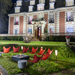 EcoSmart Base 40 fire table in garden seating area with red chairs in front of large house
