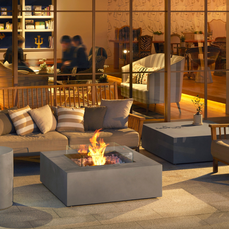 Modern patio lounge with EcoSmart Base 40 fire table surrounded by sofa seating and warm lighting