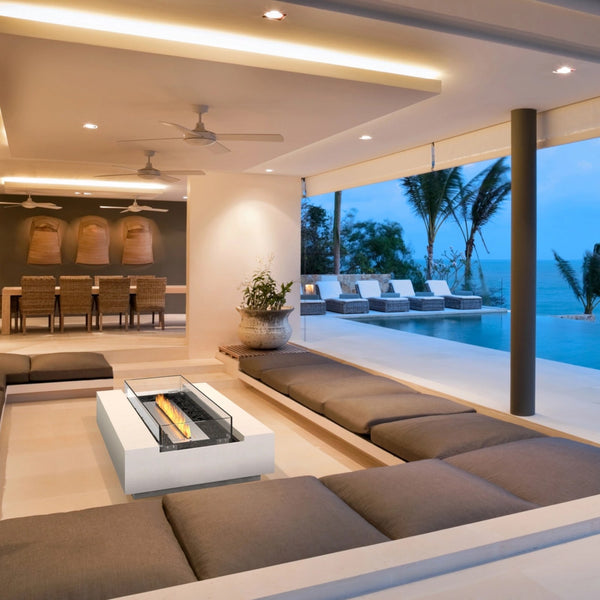 EcoSmart Cosmo 50 fire table in an open-plan poolside living space with an ocean view.