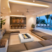 EcoSmart Cosmo 50 fire table in Bone concrete in a luxury sunken outdoor lounge next to a pool.