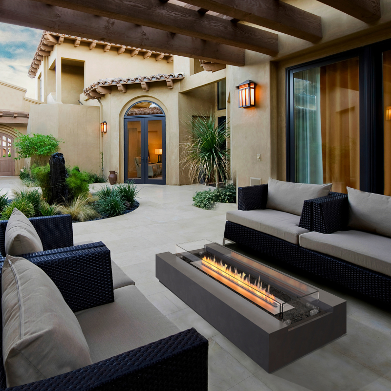 EcoSmart Cosmo 50 fire table on a modern outdoor patio with contemporary sofa seating and a glass fire screen.