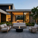 EcoSmart Mimosa 40 in Graphite on a concrete patio at dusk, surrounded by light grey armchairs in front of a contemporary glass-walled home.
