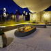 Lifestyle image of the EcoSmart Linear 50 Outdoor Fire Pit Kit in an elegant outdoor setting, with modern seating and soft lighting, creating an inviting atmosphere for entertaining guests