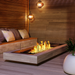 EcoSmart Linear 65 Fire Pit Kit displayed in a modern indoor setting with a wooden bench and decorative lighting