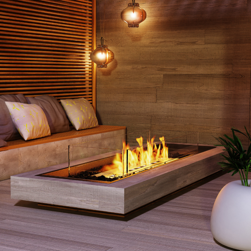 EcoSmart Linear 65 Fire Pit Kit displayed in a modern indoor setting with a wooden bench and decorative lighting