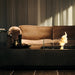 EcoSmart Manhattan 50 fire table in Graphite fluid concrete with the bioethanol flame lit in a warm evening living room.