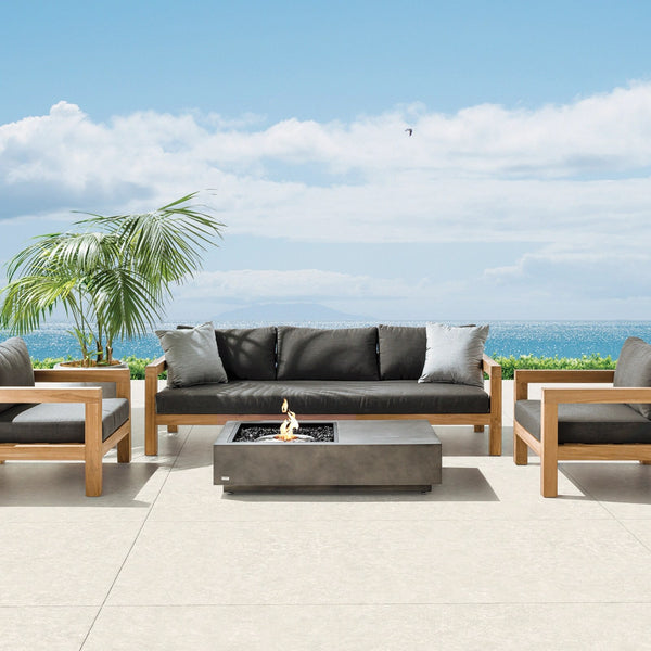 EcoSmart Manhattan 50 fire table in Graphite on an oceanfront terrace with an outdoor lounge setting.