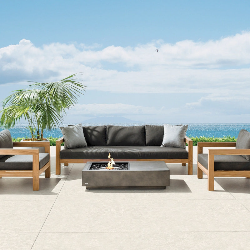 EcoSmart Manhattan 50 fire table in Graphite on an oceanfront terrace with an outdoor lounge setting.