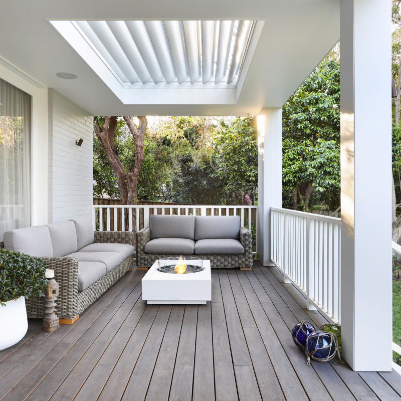EcoSmart Martini 50 in Bone Fluid concrete with a Stainless Steel burner on a porch with natural surroundings.