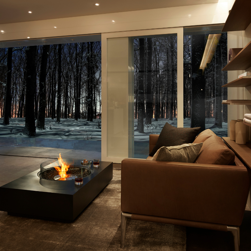 EcoSmart Martini 50 in Graphite Fluid concrete with a Black burner, indoors in a living room with a winter view.