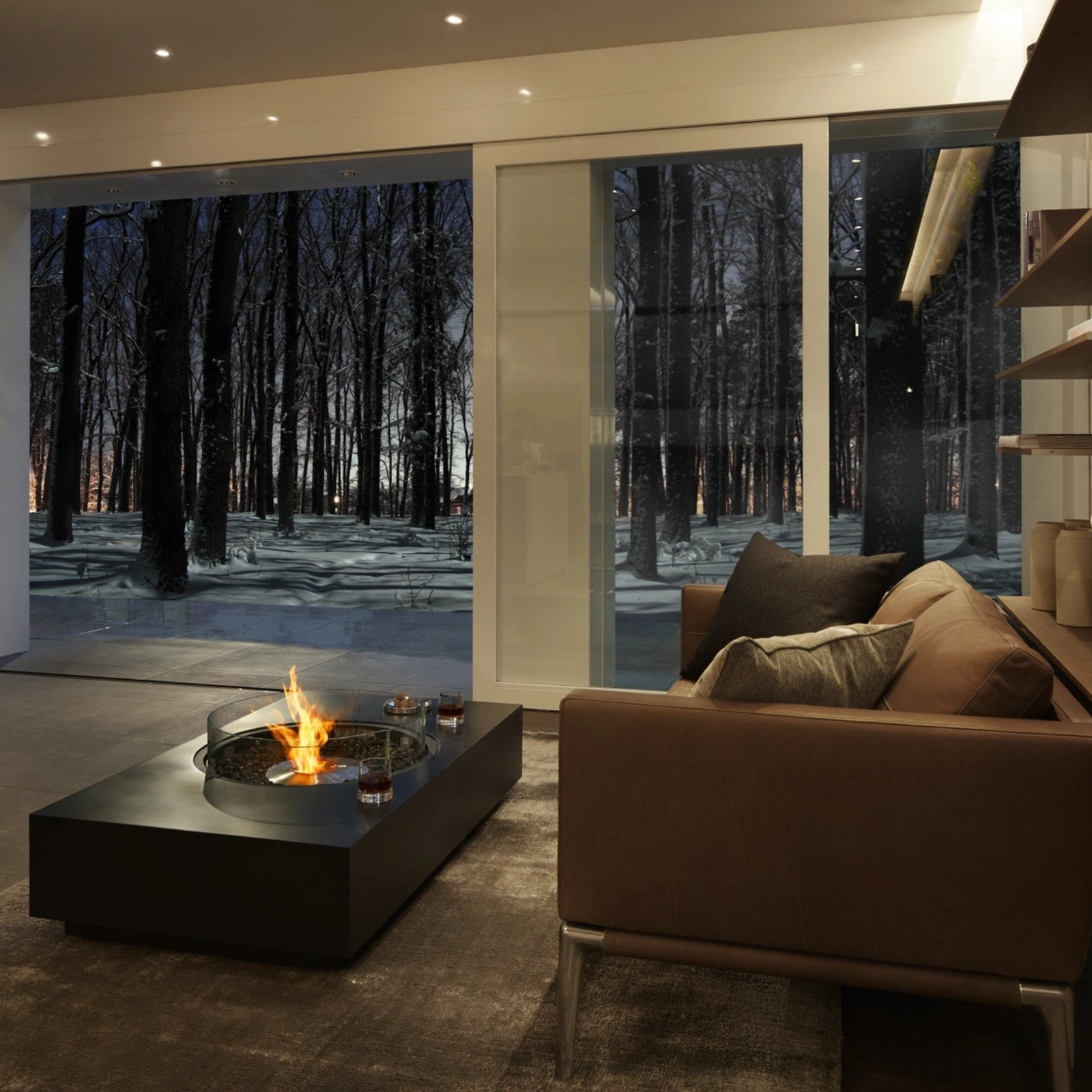 EcoSmart Martini 50 fire table in a living room with a glass screen and a forest outlook.