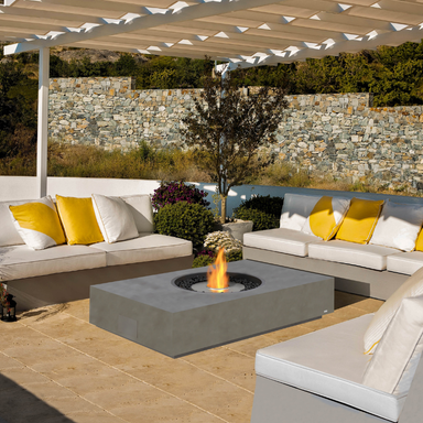 EcoSmart Martini 50 fire table in Natural Fluid concrete with a Stainless Steel sunken circular burner, on an outdoor patio.